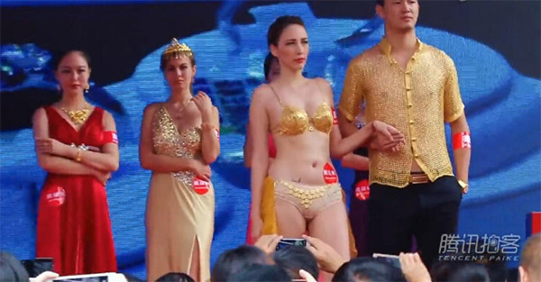Mẫu nữ mặc bikini, khoác áo lưới vàng nặng 5kg gây chú ý