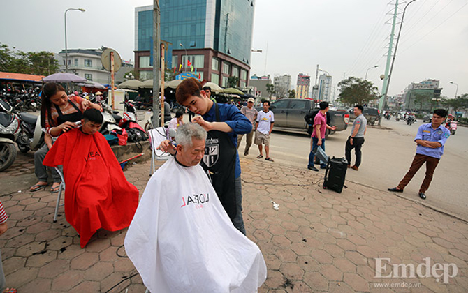 Nhiều người xếp hàng chờ cắt tóc miễn phí tại "salon"...ngoài trời
