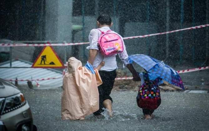 Ảnh bố đội mưa dắt 2 con làm mạng xã hội... rưng rưng cảm động