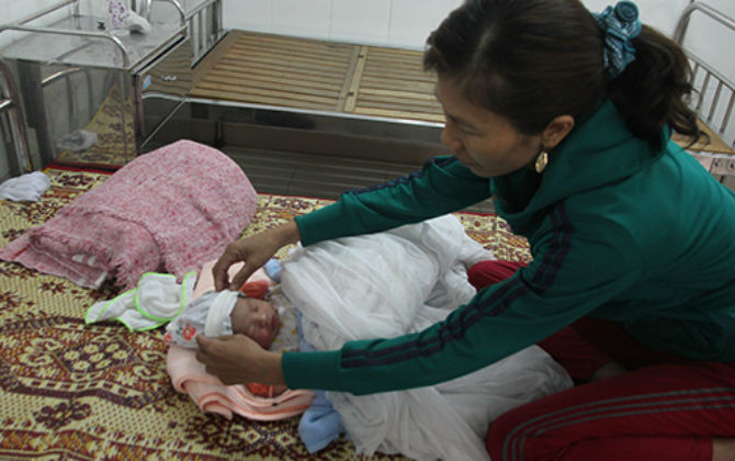 Bé trai còn nguyên dây rốn bị bỏ rơi giữa đồng, đất cát dính đầy người