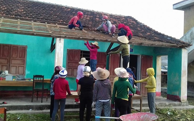 Cảm động cô giáo leo mái nhà, lợp ngói trường học sau bão số 10