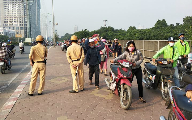 Đoàn người dắt xe máy ngược chiều trên phố Hà Nội để "né" bị CSGT phạt có phạm luật?