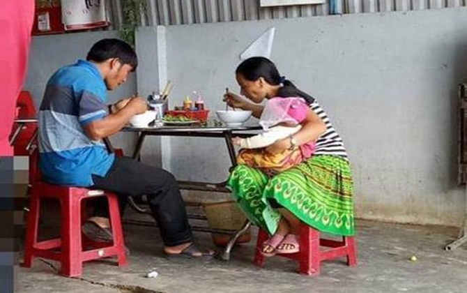 Vợ gầy gò 1 tay một bế con 1 tay ăn, chồng thảnh thơi ngồi như người son rỗi: Bức ảnh khiến ai xem cũng chạnh lòng