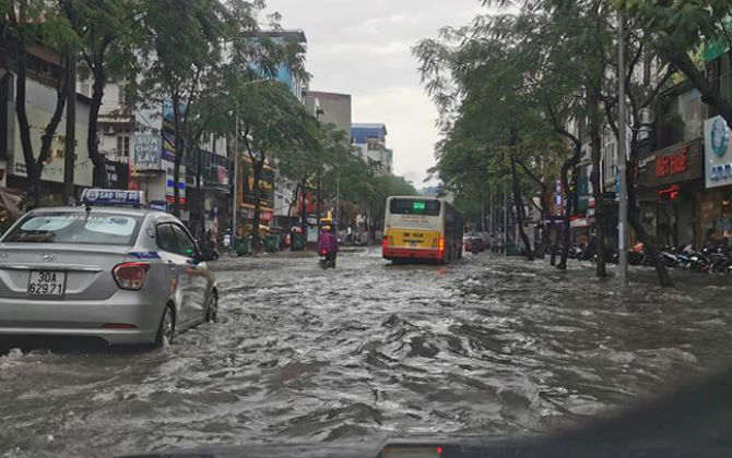 Cơn mưa lớn đổ xuống khiến bầu trời Hà Nội đầu giờ chiều như 6h tối, đường ngập bì bõm lội nước