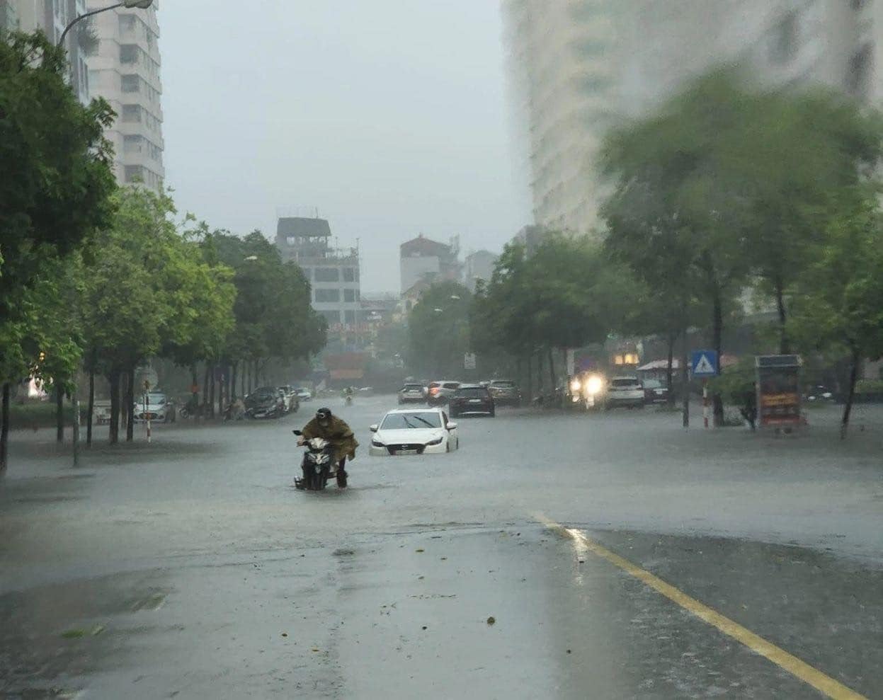 Mưa như trút xuống Hà Nội sau chuỗi ngày nắng nóng khốc liệt, nhiều tuyến đường lại ngập, xe cộ bì bõm đi lại